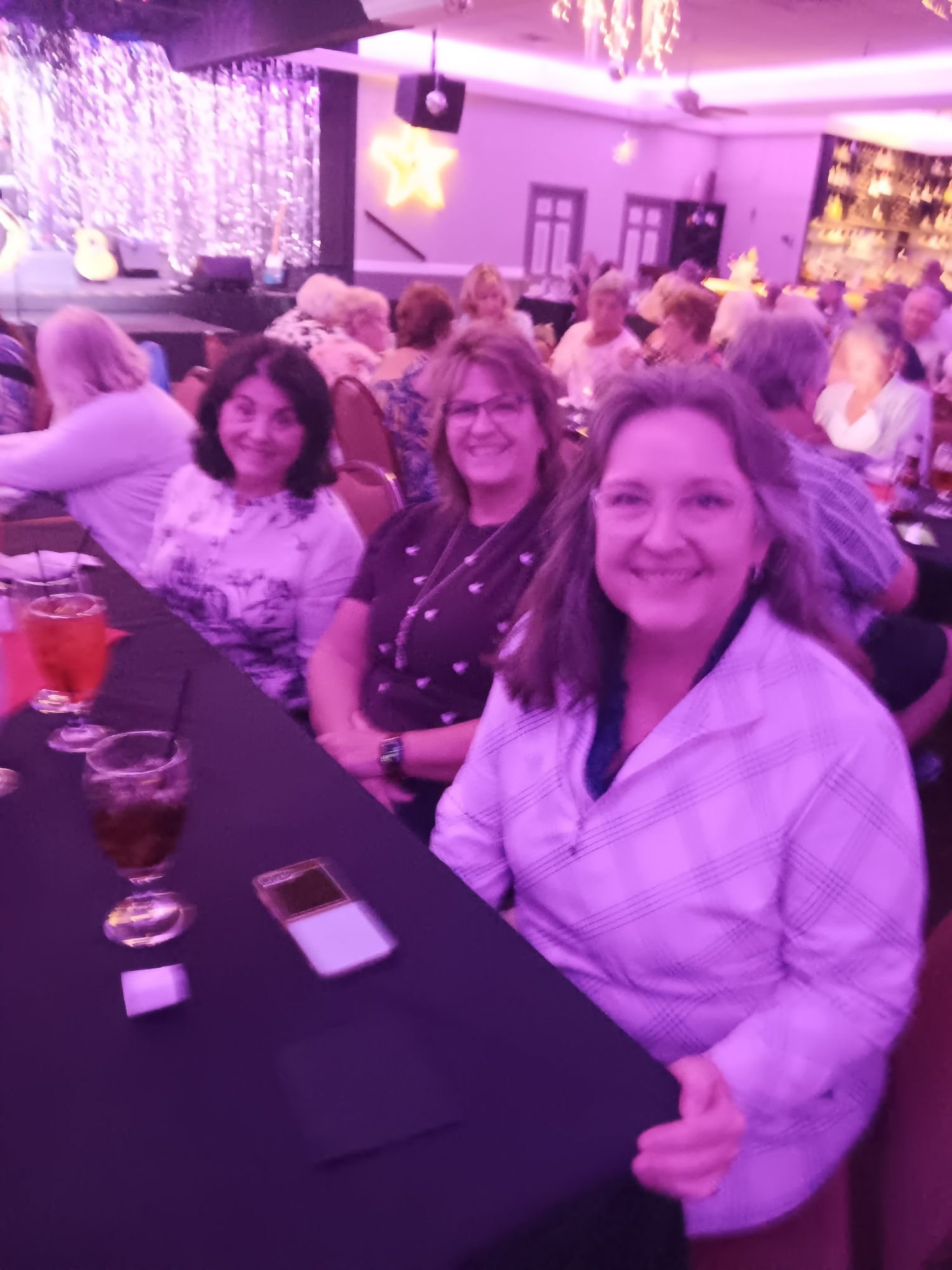 Anita Kardon, Leyna Hoffer and Suzanne Dugger smiling at their table