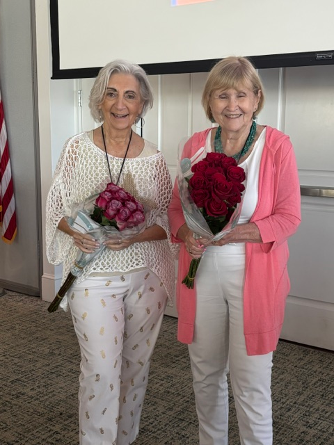 Lynn Lewis and Patti Heath holding bouquets of roses