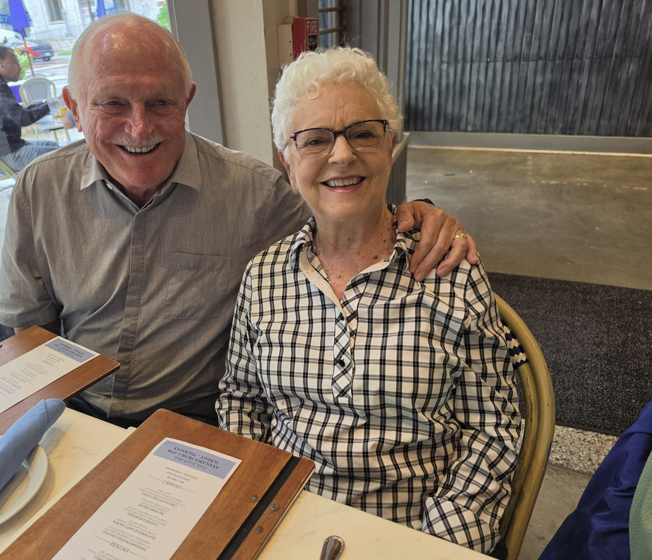 A couple seated together at a restaurant table