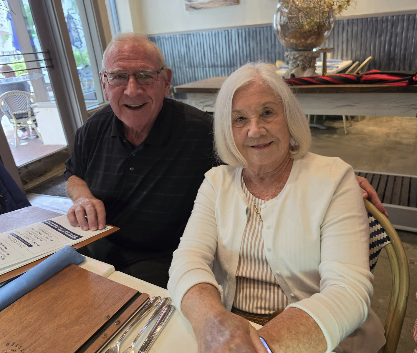 A couple smiling at their restaurant table