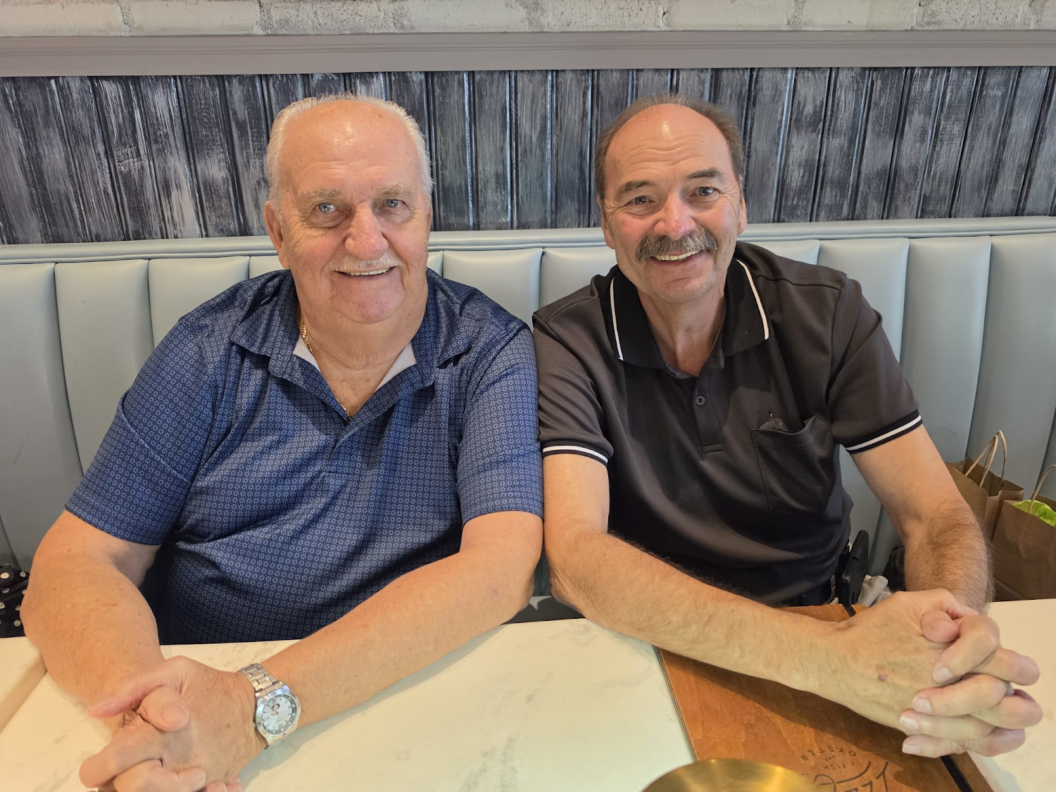 Two men seated side by side at dinner