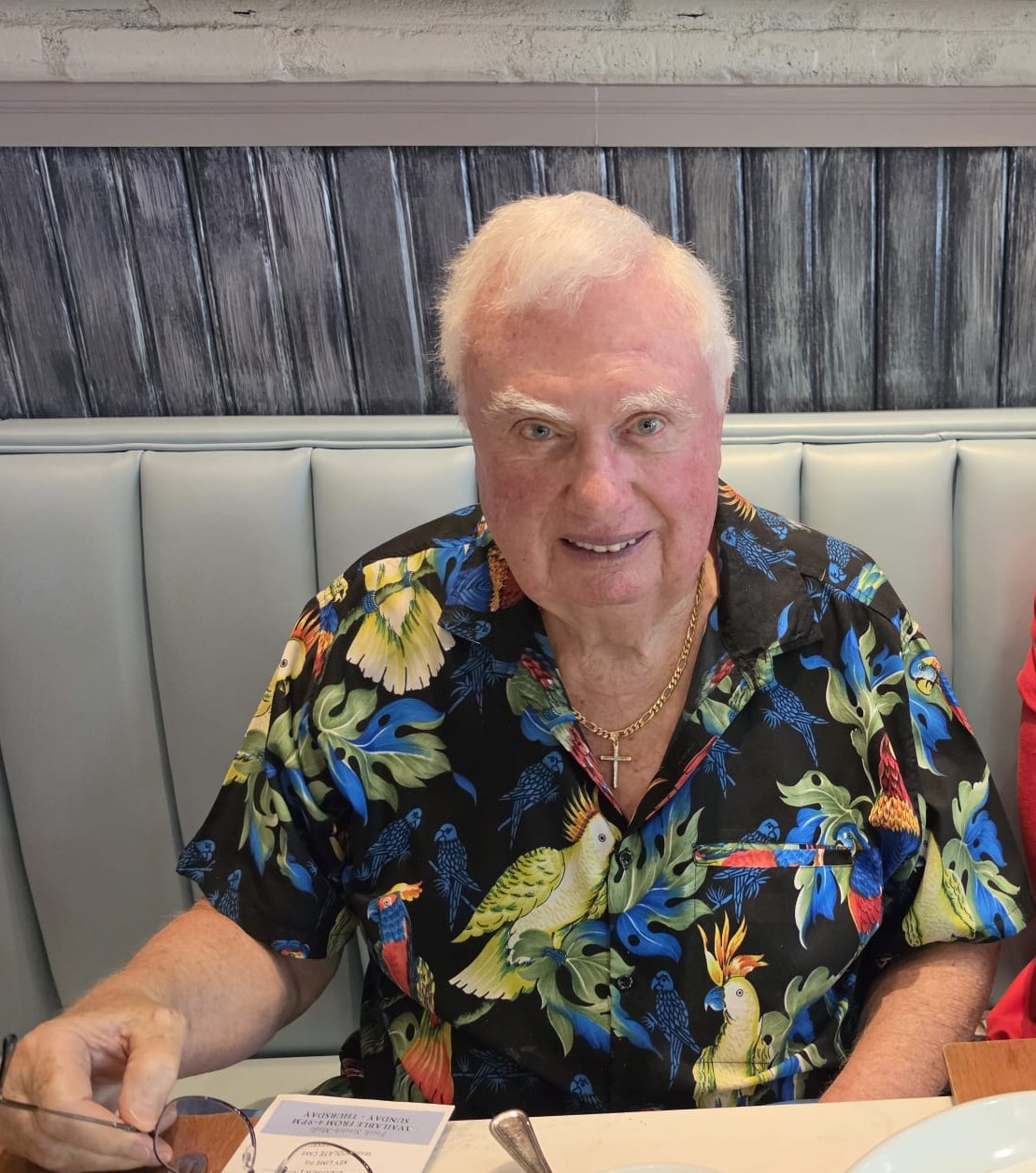 A man in a patterned shirt at the dinner table