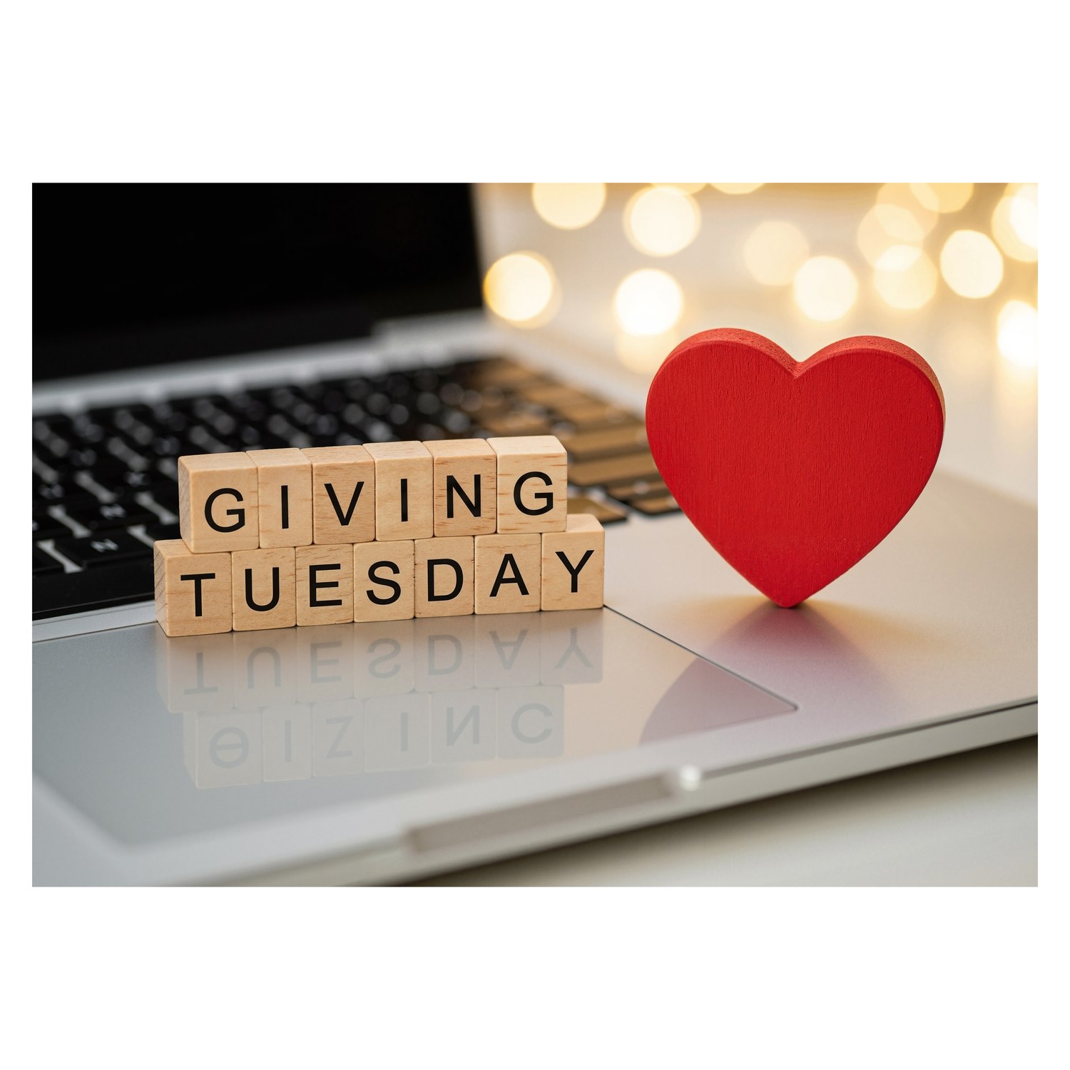 Giving Tuesday letter tiles and a red heart on a laptop